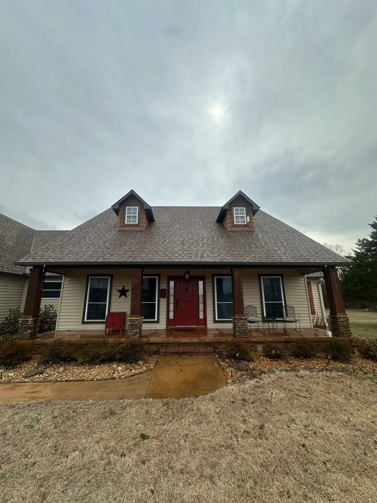 Before soft washing: front of a Heber Springs home with algae and dirt staining the siding
