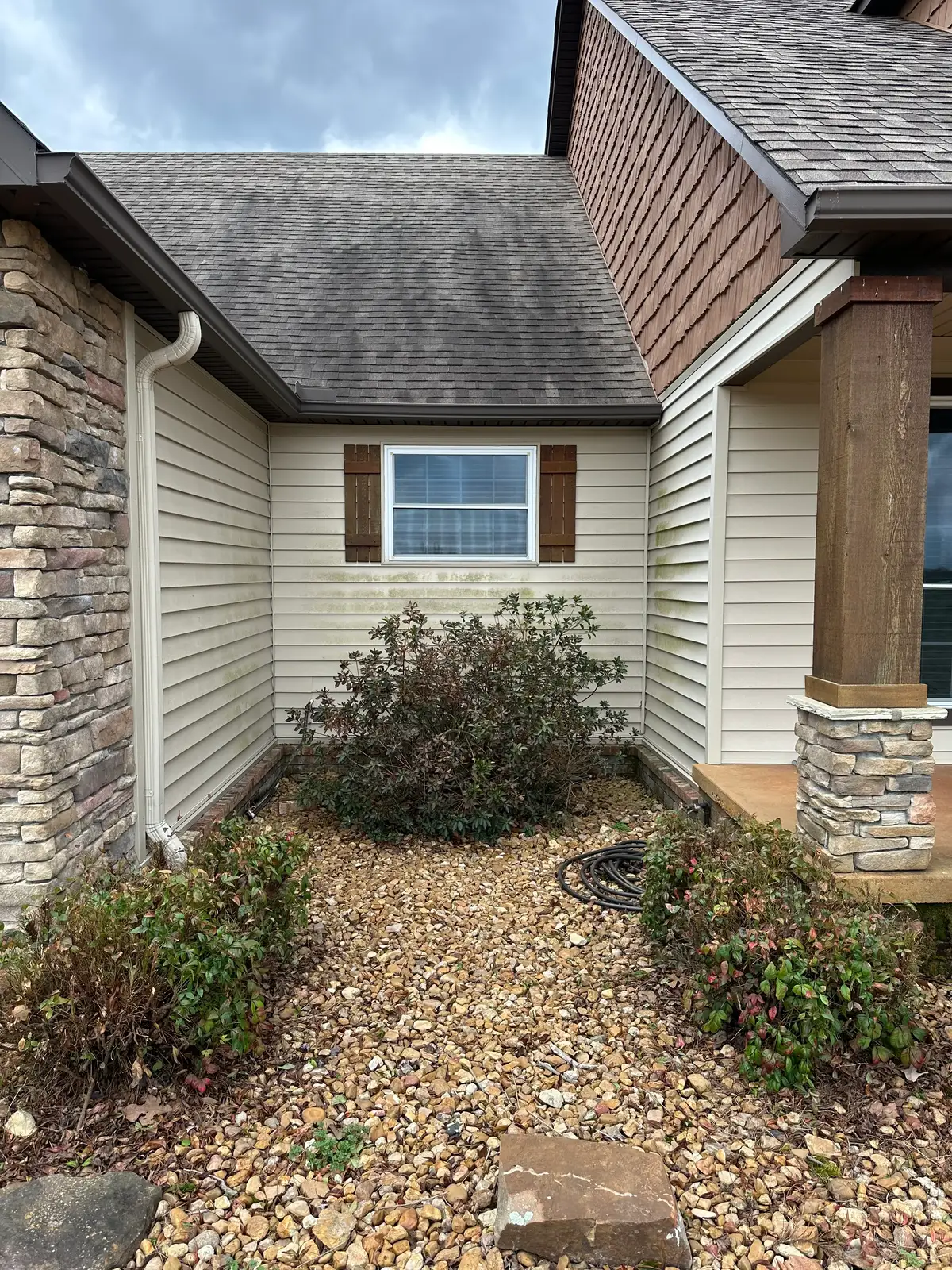 Courtyard wall of a Heber Springs home before soft washing — mildew and grime on the exterior