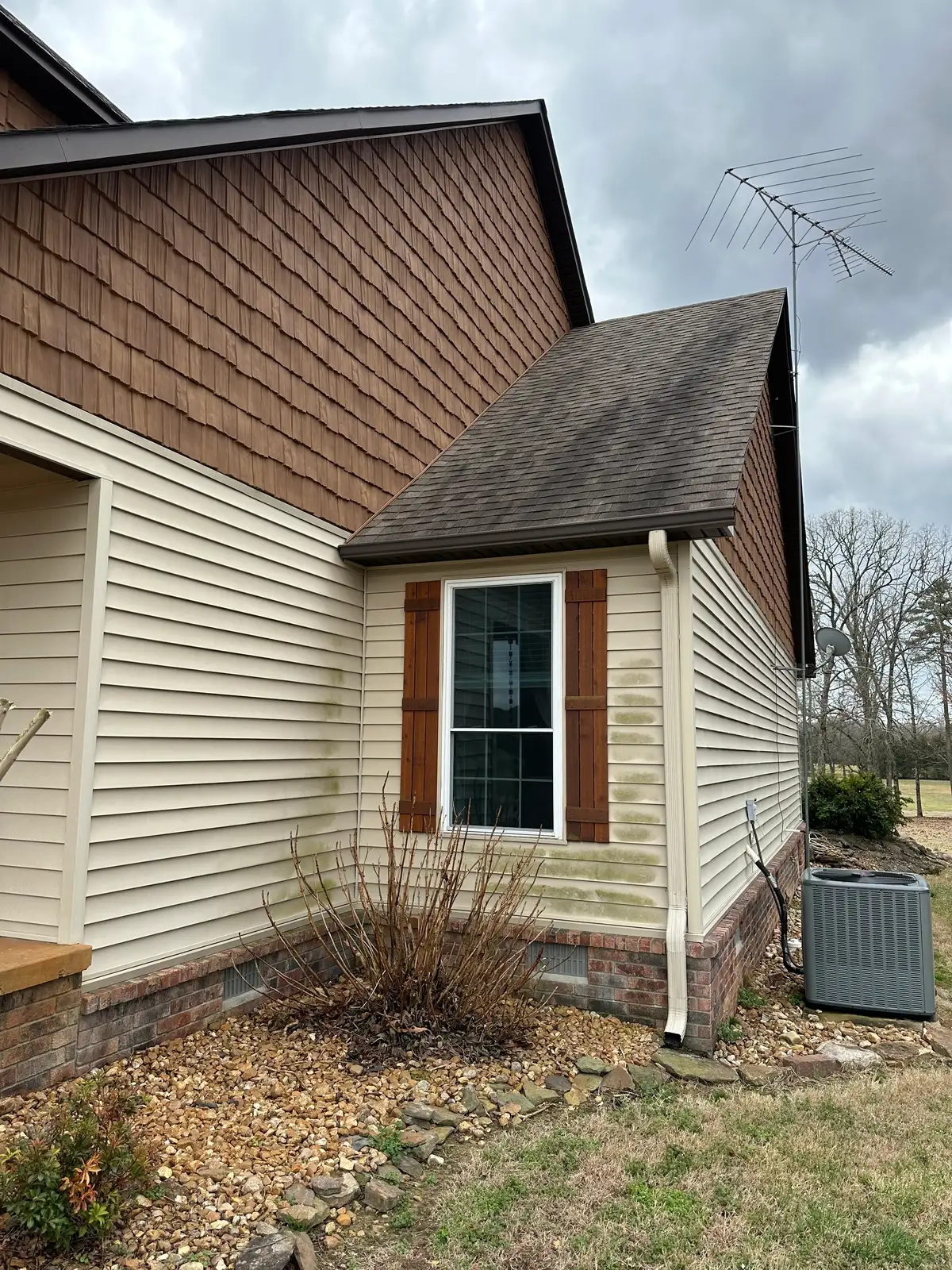 Soft washed house siding beside power washed concrete on a Heber Springs property