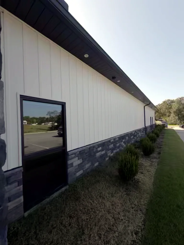 Commercial building long wall in Heber Springs, Arkansas before soft washing — algae and weather staining on the exterior