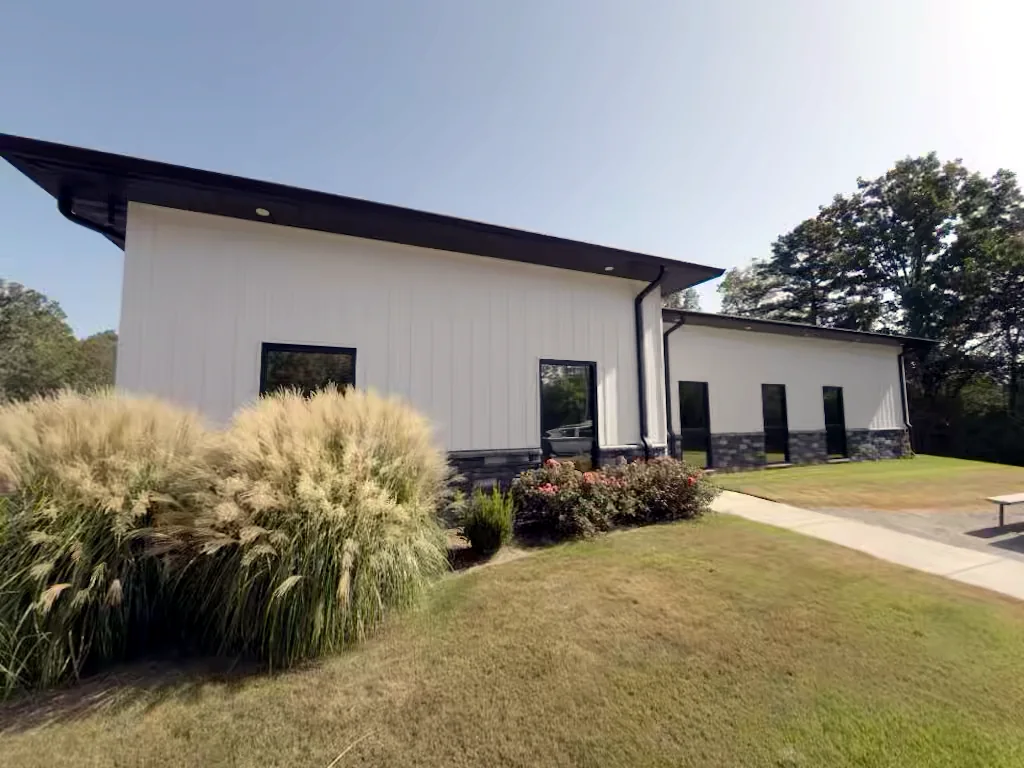Commercial building landscape side in Heber Springs, Arkansas before soft washing — algae and weather staining on the exterior