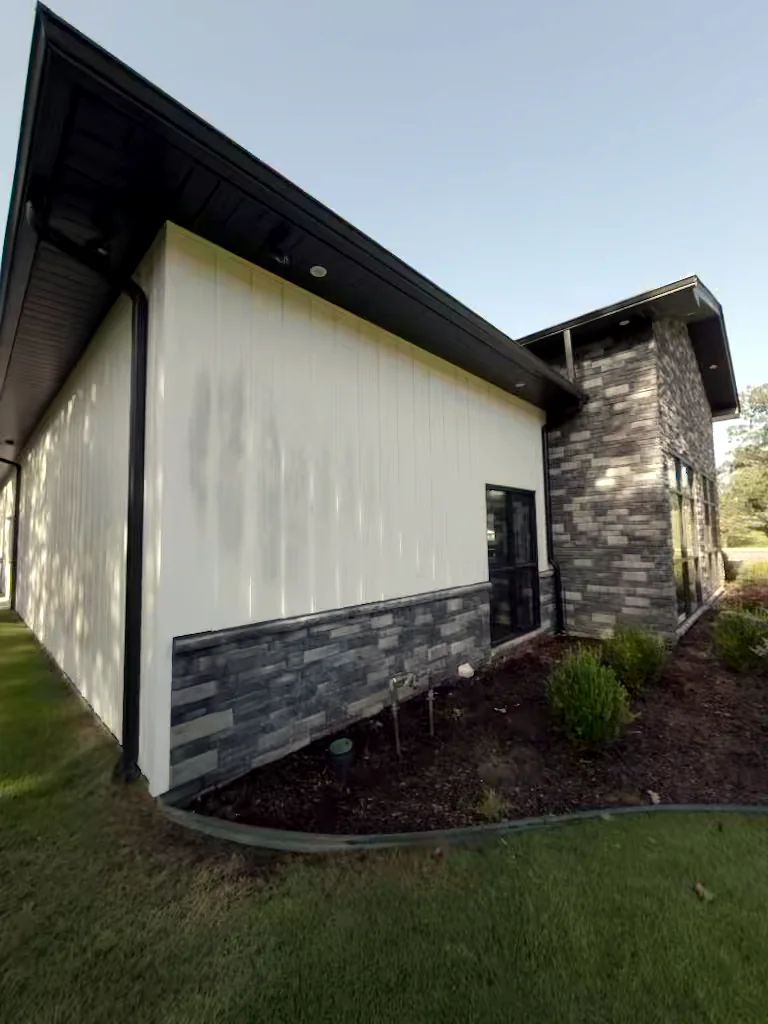 Commercial building stone wall in Heber Springs, Arkansas before soft washing — algae and weather staining on the exterior